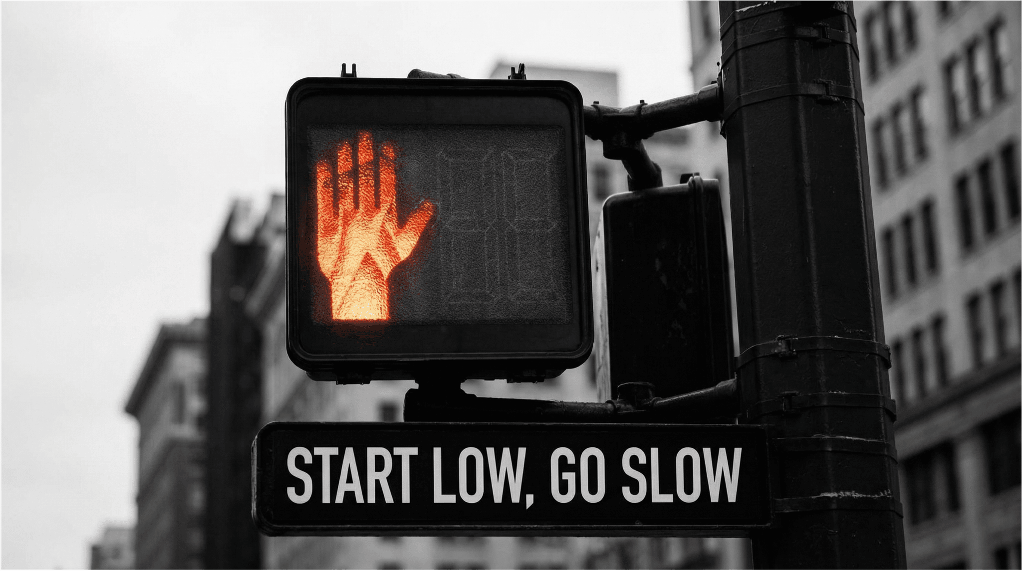 Nahaufnahme eine roten Ampel mit dem Schriftzug "Start low, go slow"