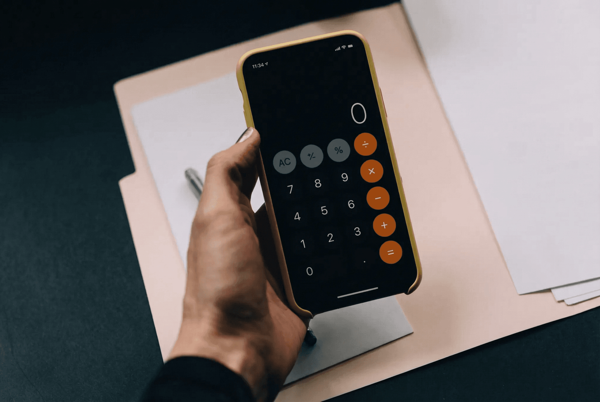 Eine Hand hält ein Handy mit einer geöffneten Taschenrechner-App