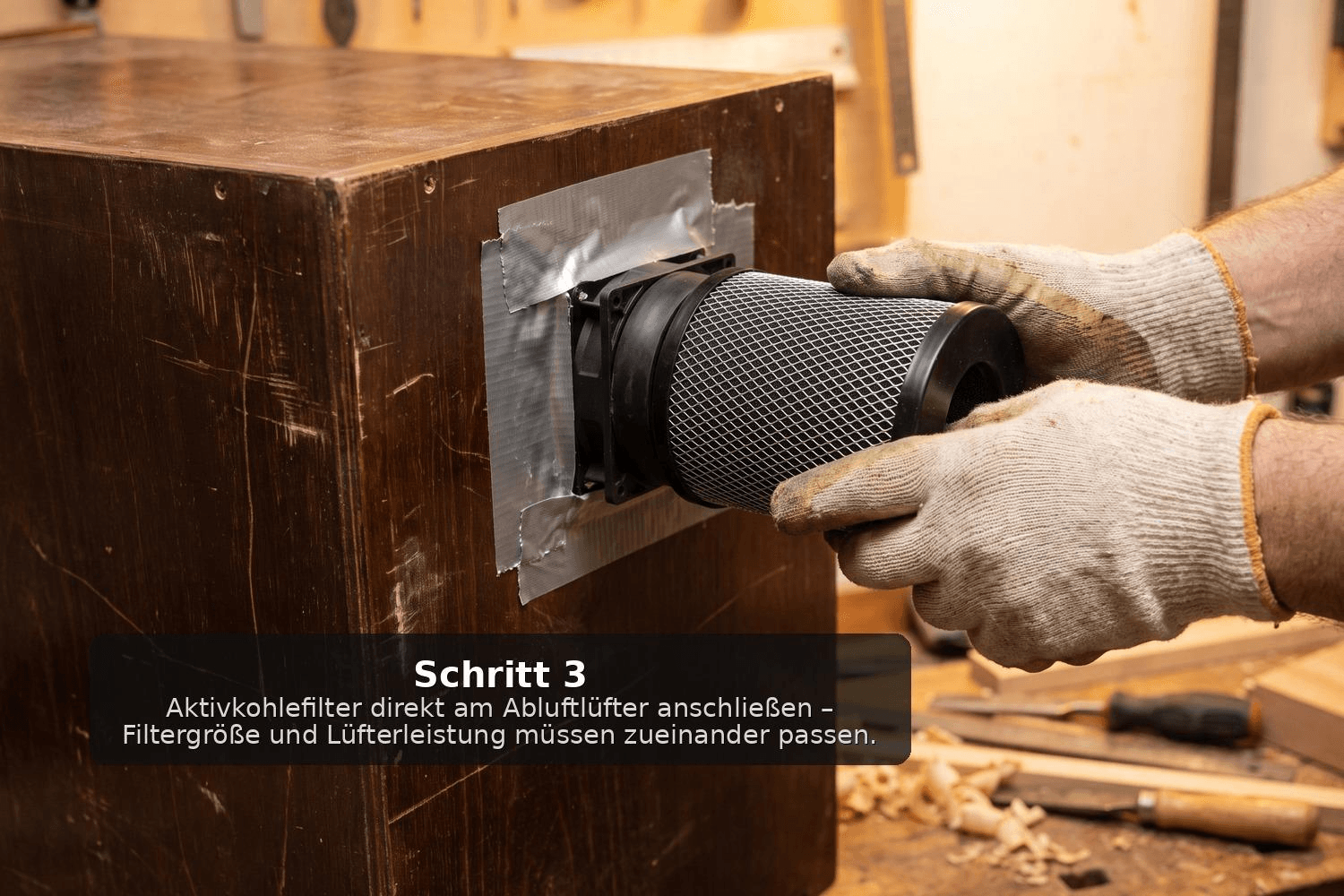 Hände stecken einen Aktivkohlefilter direkt auf den bereits in der Holzwand montierten Abluftlüfter einer selbstgebauten Cannabis-Trockenbox