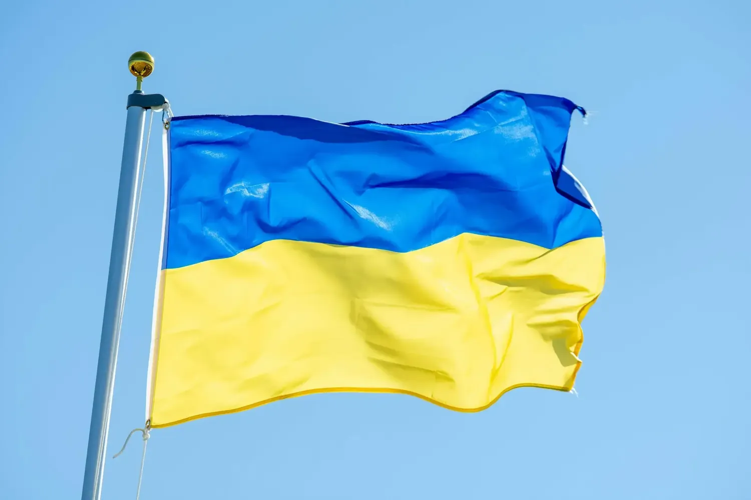 Blaue und gelbe Flagge der Ukraine weht am Mast