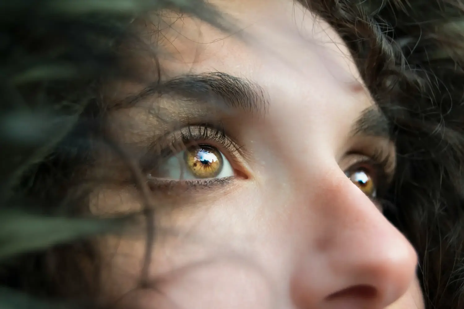 Nahaufnahme goldbraunes Auge, Himmelreflexion, lange Wimpern