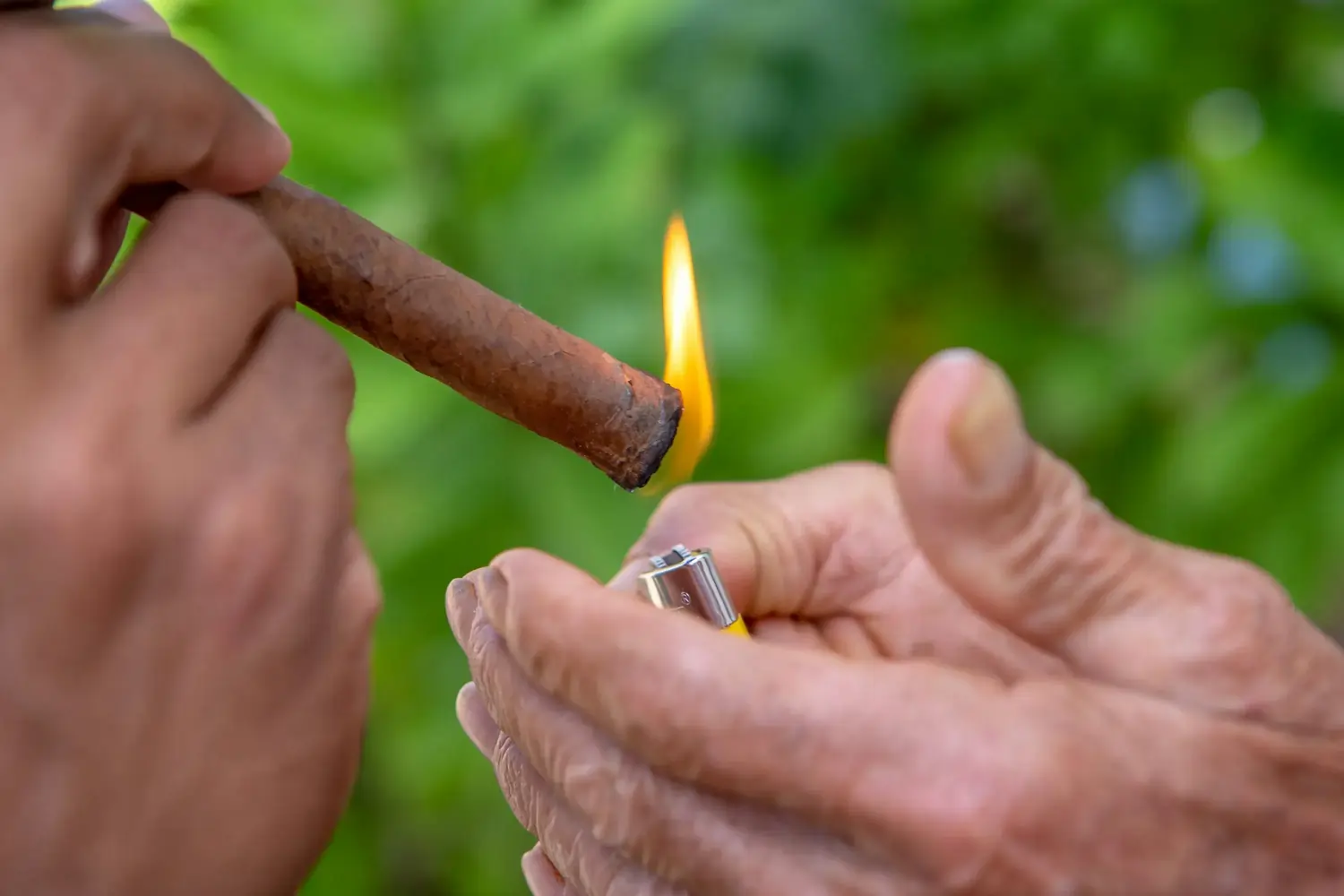 Hände halten Blunt, Feuerzeugflamme entzündet das Ende